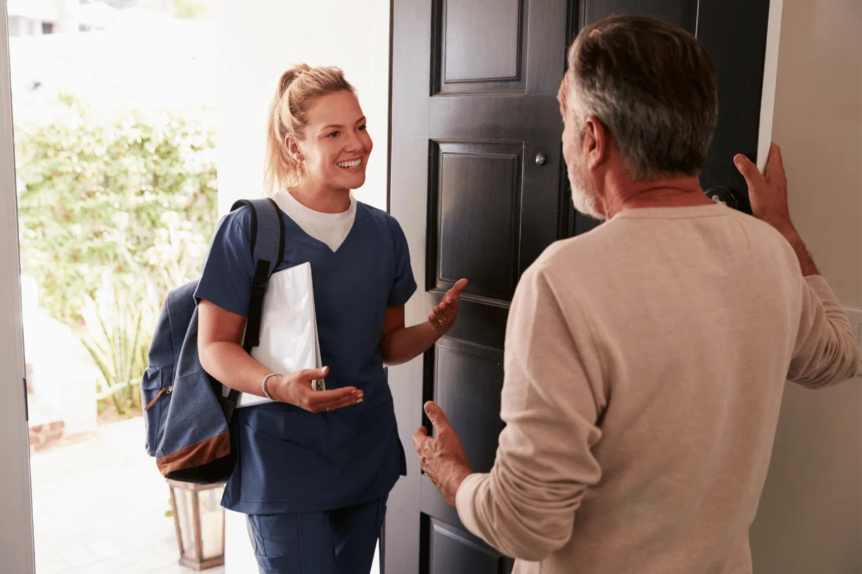 Nurse being greeted by man at front door