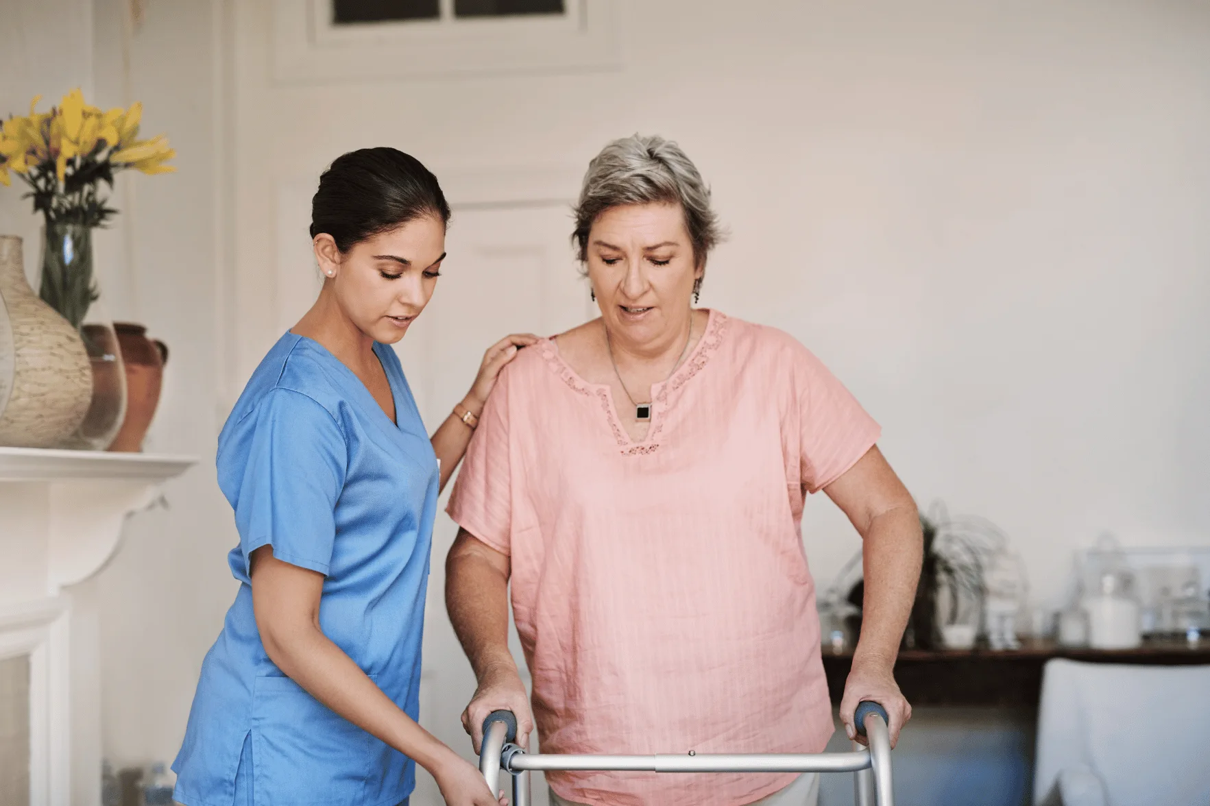 Nurse helping woman walk with walker