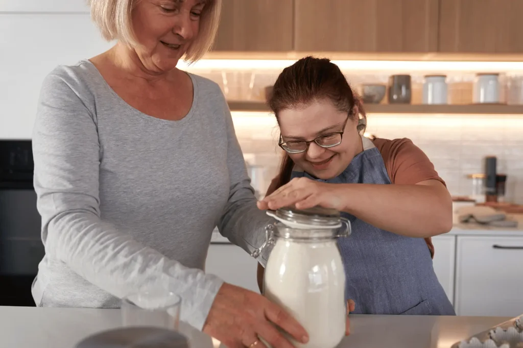 Support worker baking with disabled woman